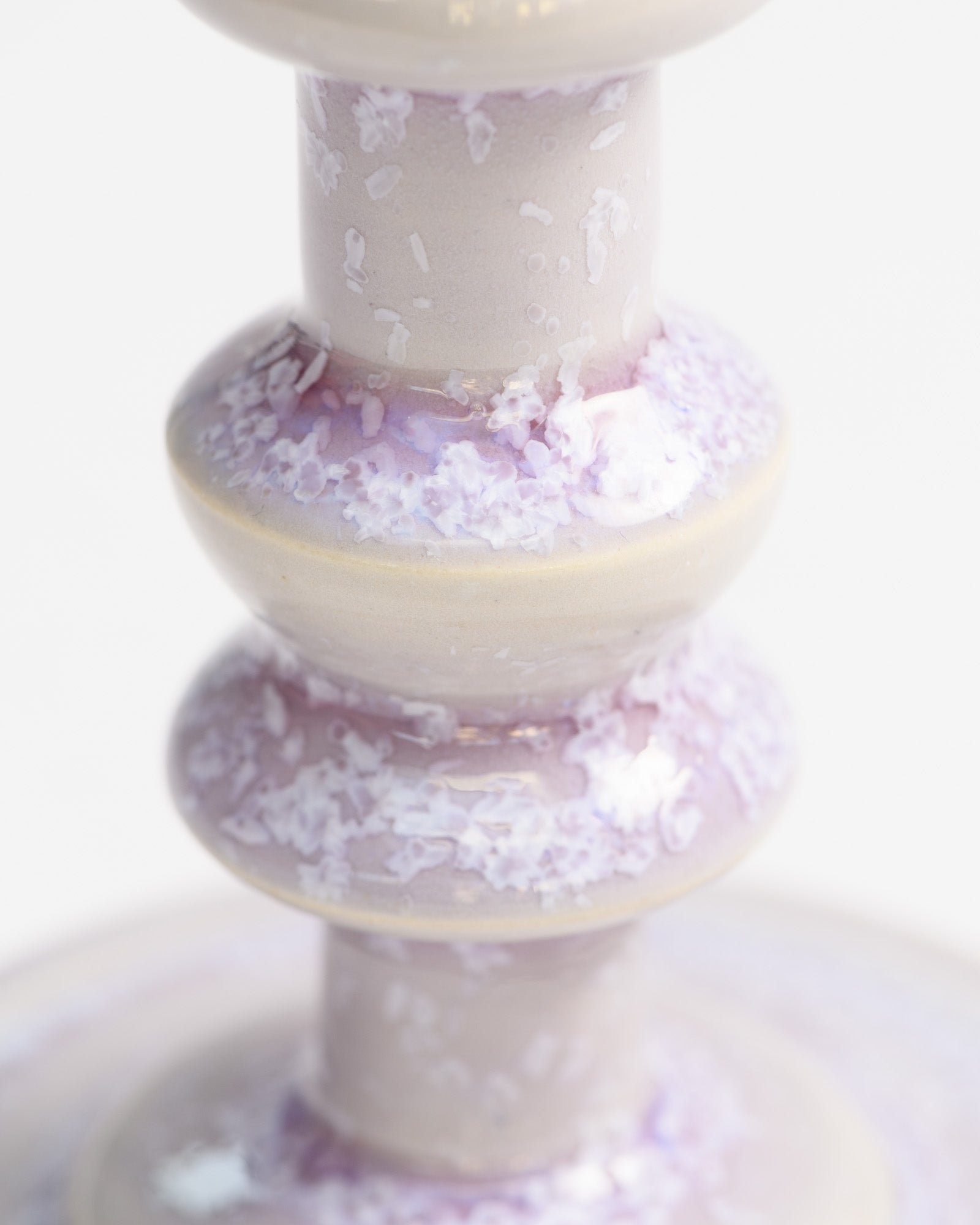 Close up of a tall candlestick glazed in lilac