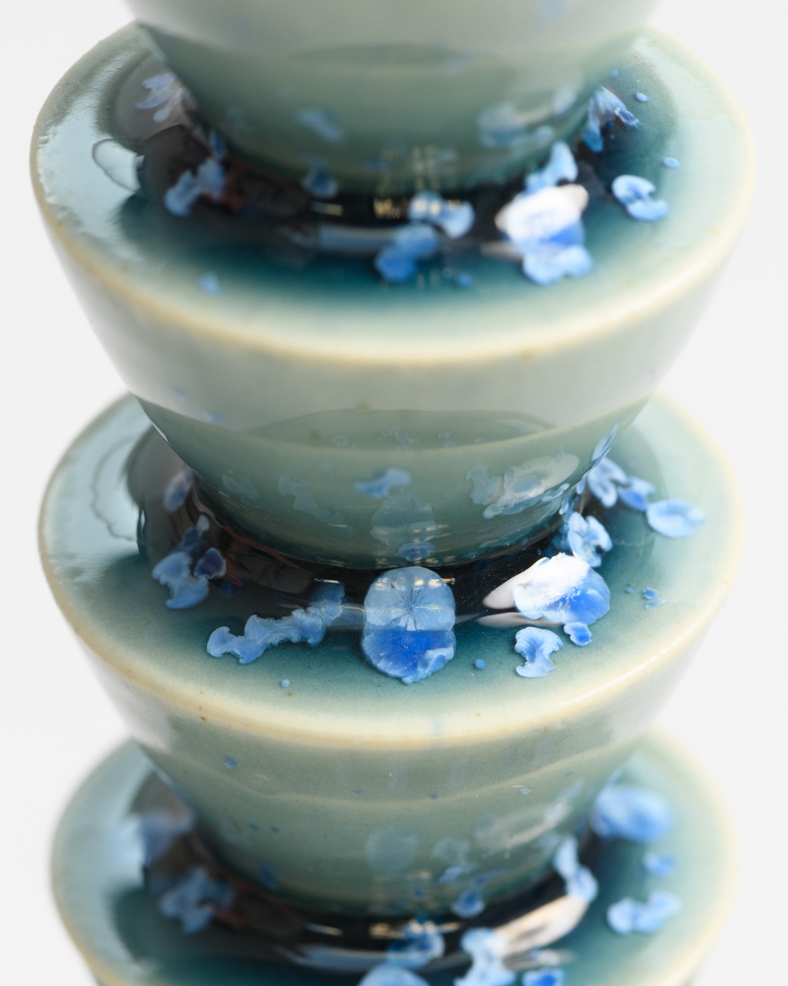 Close up of a tall candlestick glazed in teal